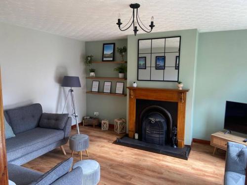 a living room with a couch and a fireplace at Whitepark Cottage - your home away from home in Ballycastle