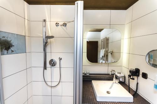 een badkamer met een douche en een wastafel bij Rebgarten Hotel Adler in Pfullendorf