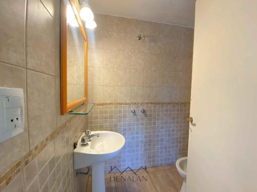 a bathroom with a sink and a toilet at Departamento Denalan in Villa Gesell