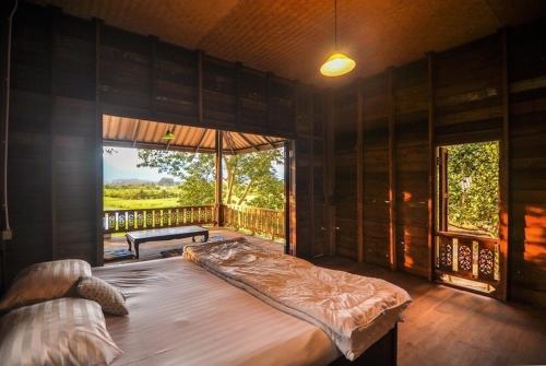 a large bed in a room with a large window at 467 Chiang Dao in Chiang Dao