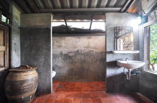 a bathroom with a toilet and a sink and a barrel at 467 Chiang Dao in Chiang Dao