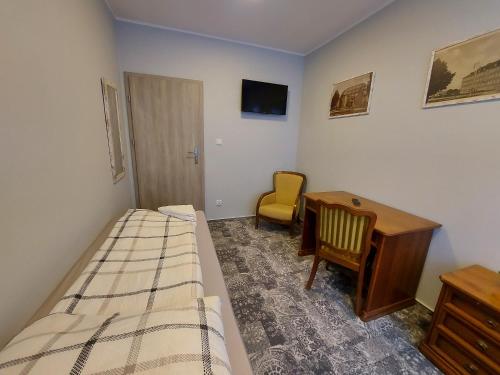 um quarto com uma cama, uma secretária e uma cadeira em Kamienica1924 em Szczecinek