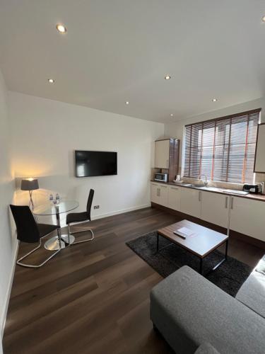 a living room with a table and a couch at Howburn Residence Serviced Apartments in Aberdeen
