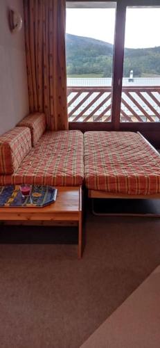 une chambre avec deux bancs devant une fenêtre dans l'établissement Appartement bien situé, à Gresse-en-Vercors