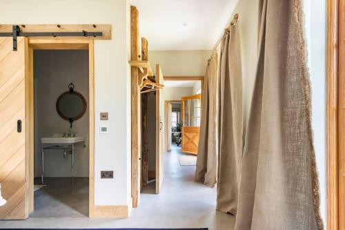 a hallway of a house with curtains in a room at Fledgling Barn: stunning new coastal holiday home in Kingsbridge