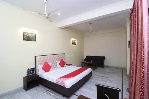 a hotel room with a bed and a chair at OYO Hotel Ayaan in Bareilly