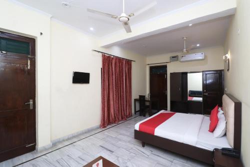 Schlafzimmer mit einem Bett, einem Fenster und einer Tür in der Unterkunft OYO Hotel Ayaan in Bareilly