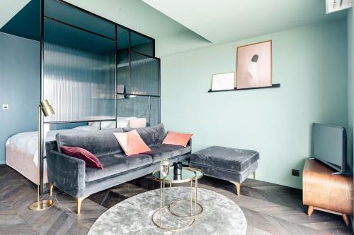 a bedroom with a couch and a bed and a tv at Luxueuze suite met frontaal zeezicht in Knokke-Heist
