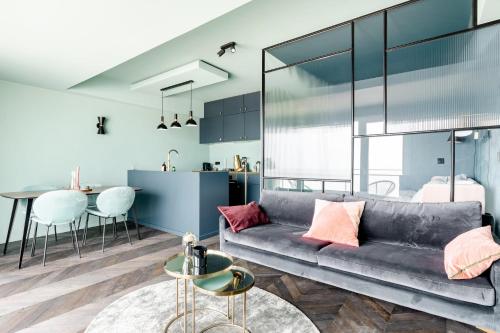 a living room with a couch and a table at Luxueuze suite met frontaal zeezicht in Knokke-Heist