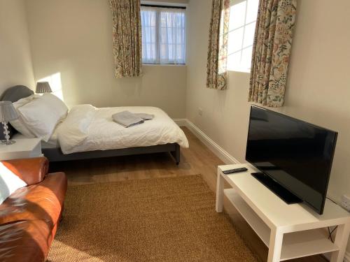 a living room with a bed and a flat screen tv at Potcote farm stables accommodation spots stable in Towcester
