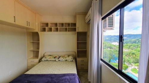 a small bedroom with a bed and a window at Mirante das Aguas de Piratuba in Piratuba