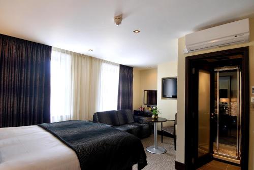 una camera d'albergo con letto e divano di The Marble Arch Suites a Londra