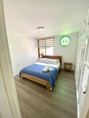 a bedroom with a bed with blue sheets and a window at Apartamento Calle Real in Quimbaya