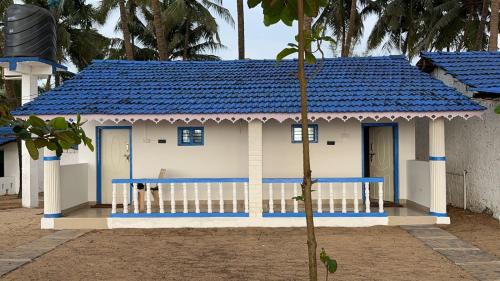 a small blue and white house with a blue roof at Vibes and Tides Beach Resort by Enlightened Vagabond in Gokarna
