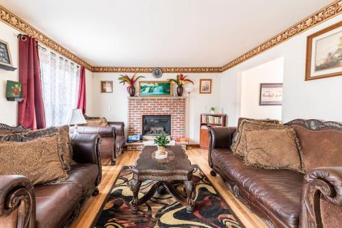 a living room with leather couches and a fireplace at Cheerful Pocono home away from home in Albrightsville