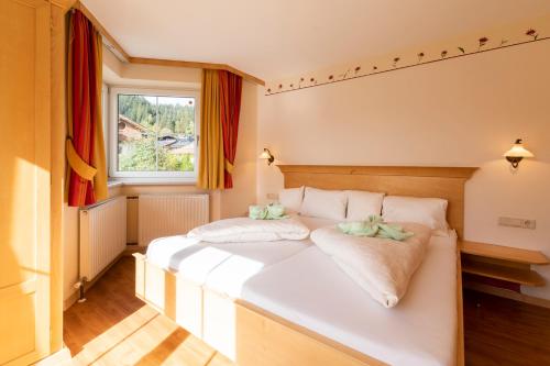 uma cama branca num quarto com uma janela em Residenz Theresa em Söll