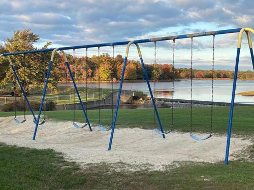 a swing set in a park next to a lake at Cheerful Pocono home away from home in Albrightsville
