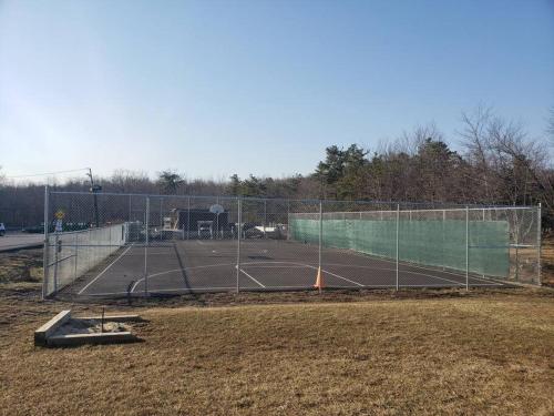 a tennis court with a fence around it at Cheerful Pocono home away from home in Albrightsville