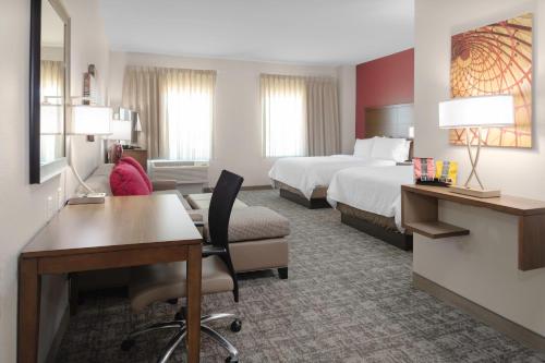 um quarto de hotel com uma secretária e uma cama em Staybridge Suites - Cedar Park - Austin N, an IHG Hotel em Cedar Park