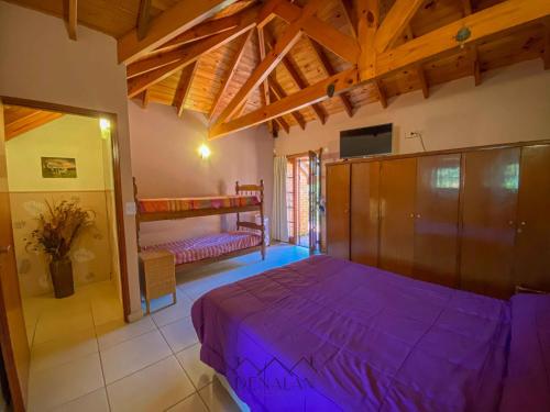 1 dormitorio con 1 cama de color púrpura en una habitación en Casa Tinta Roja 1 en Villa Gesell