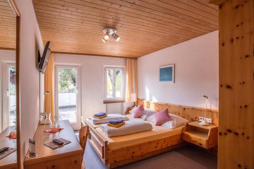 ein Schlafzimmer mit einem Bett und einer Holzdecke in der Unterkunft Hotel Chalamandrin in Ftan