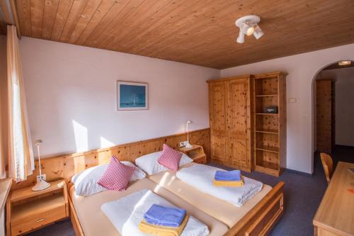 a bedroom with two beds and a wooden ceiling at Hotel Chalamandrin in Ftan