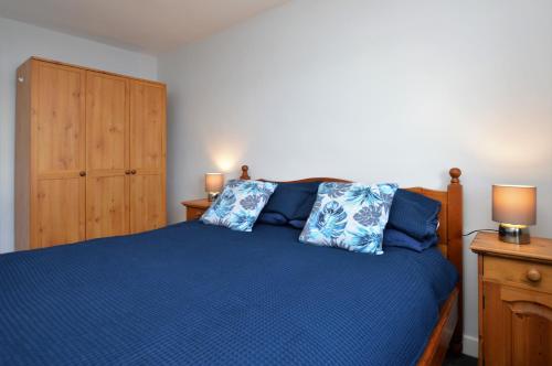 a bedroom with a blue bed with two blue pillows at Anchor View in Ardrishaig