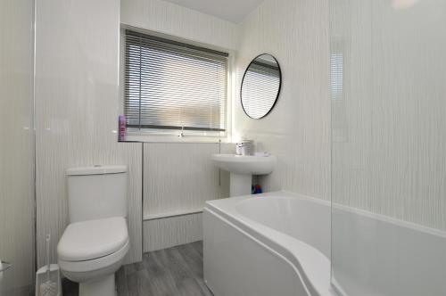 a white bathroom with a toilet and a sink at Anchor View in Ardrishaig