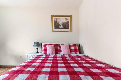 a red and white bed with a red and white blanket at Cheerful Pocono home away from home in Albrightsville