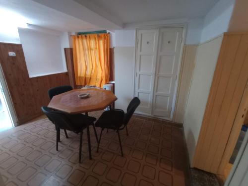 Zimmer mit einem Holztisch und schwarzen Stühlen in der Unterkunft Lomas del Uritorco - Casa de Alq x Temp in Capilla del Monte