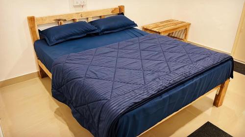 a bed with a blue comforter in a room at Vibes and Tides Beach Resort by Enlightened Vagabond in Gokarna