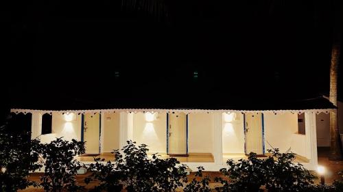a white building with lights on it at night at Vibes and Tides Beach Resort by Enlightened Vagabond in Gokarna