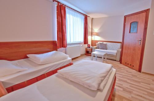 ein Hotelzimmer mit 2 Betten und einem Sofa in der Unterkunft City Hostel in Stettin