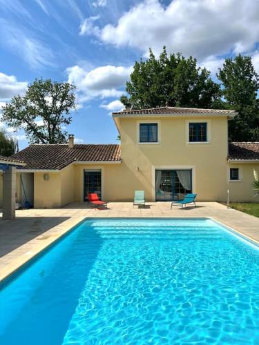 une grande piscine bleue devant une maison dans l'établissement Maison de vacances avec piscine, à Chancelade