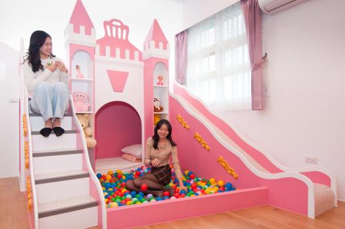 a girl sitting on a ball pit in a castle play room at Michelin Castle - Yilan Homestay in Wujie