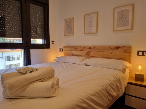 a bedroom with two beds with white sheets and a desk at 604B - Apartamento con garaje in Oviedo