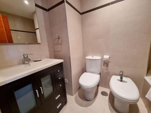a bathroom with a white toilet and a sink at 604B - Apartamento con garaje in Oviedo