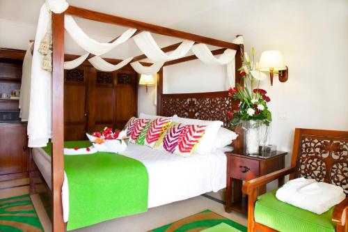 a bedroom with a canopy bed and two chairs at Gafy Resort Aqua Park in Sharm El Sheikh