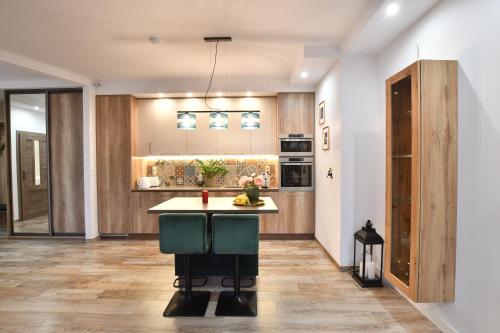 a kitchen with a island in the middle of a room at Green Penthouse in Grudziądz