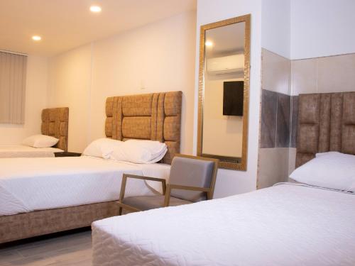 a hotel room with two beds and a mirror at HOTEL GOLDEN CARTAGO in Cartago