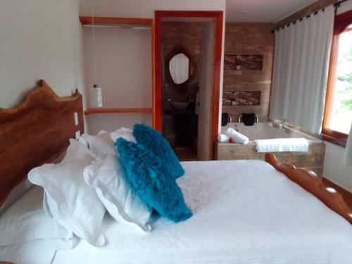 a bedroom with a white bed with blue pillows at Hospedaje Vista Hermosa Salento in Salento