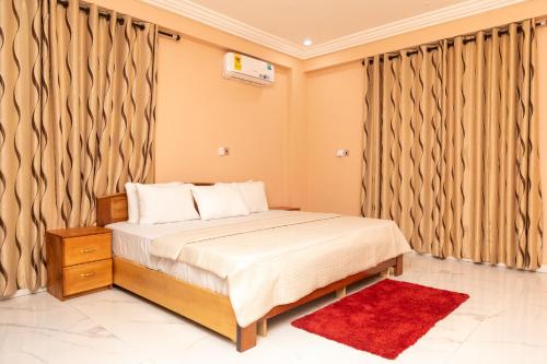 Un dormitorio con una cama con cortinas y una alfombra roja. en 2Bed Apartment Sleeps 4 - Parking Wifi, en Accra