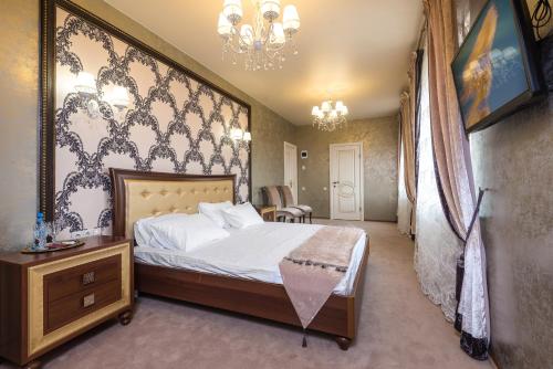 1 dormitorio con cama y lámpara de araña en Гостиница Альвита Краснодар Центр, en Krasnodar