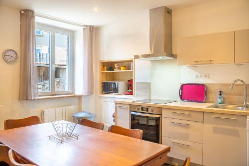 une cuisine avec une table en bois et une salle à manger dans l'établissement Le Chardon Bleu, jardin, centre-ville, Saint-Côme-d'Olt, à Saint-Côme-dʼOlt
