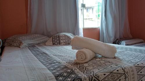 um quarto com uma cama com toalhas em Pousada Casa da Neuzita em Lençóis