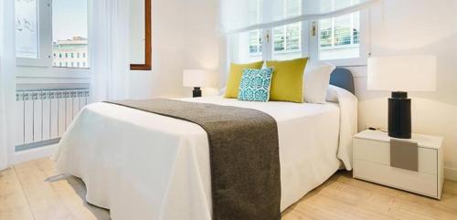 een slaapkamer met een groot wit bed met gele en blauwe kussens bij Luxury Madrid Centro in Madrid