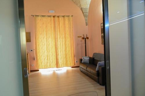 - un salon avec un canapé et un rideau jaune dans l'établissement The Nest of Envy, à Bari