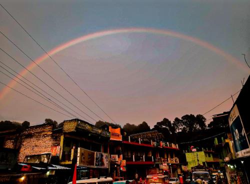 a rainbow in the sky over a city at B2 Guest House in Almora
