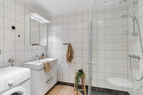 een witte badkamer met een wasmachine en een wastafel bij Modern apartment in the center of Bergen in Bergen