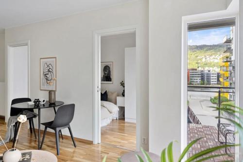 een witte woonkamer met een tafel en een raam bij Modern apartment in the center of Bergen in Bergen